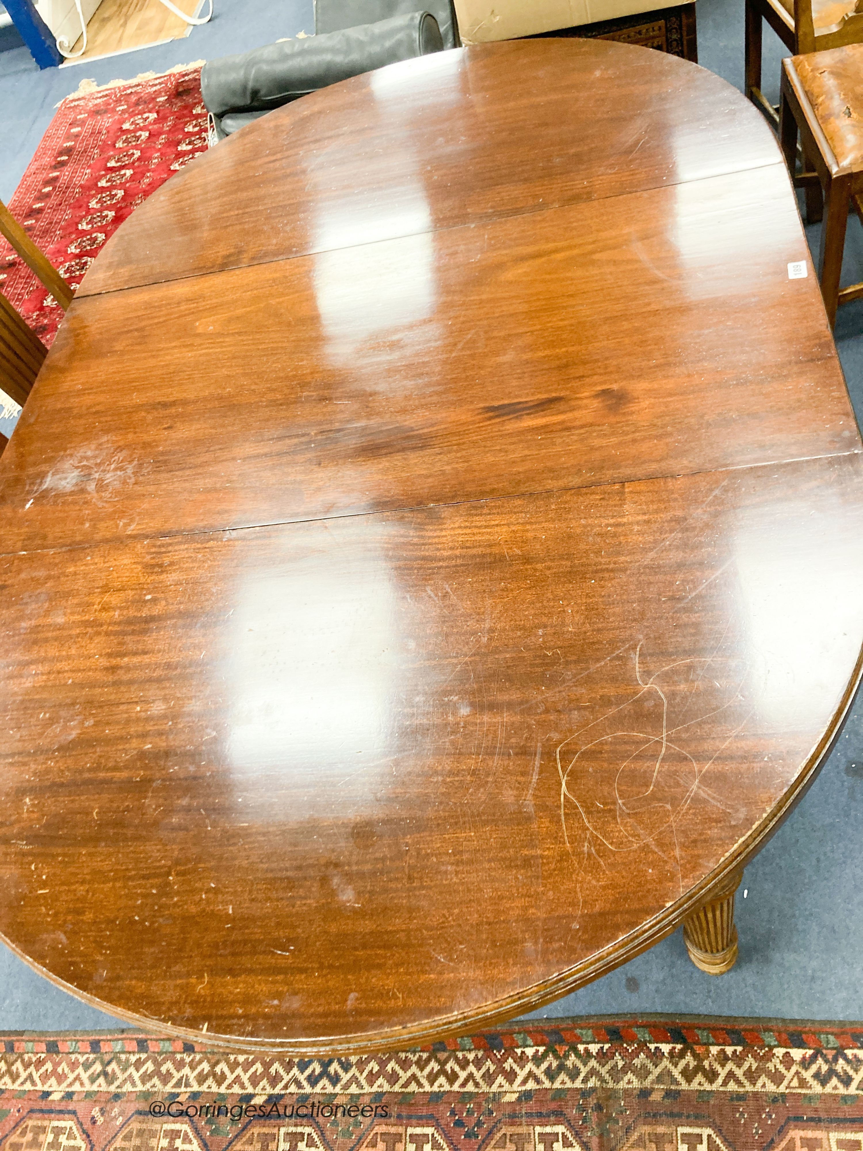 An Edwardian mahogany oval extending dining table, length 180cm extended with one spare leaf, width 120cm, height 74cm together with four George III style mahogany dining chairs